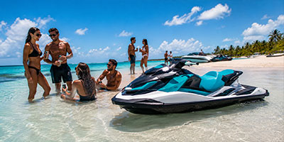A jet ski beached at a sandbar where a group of people are enjoying the water.